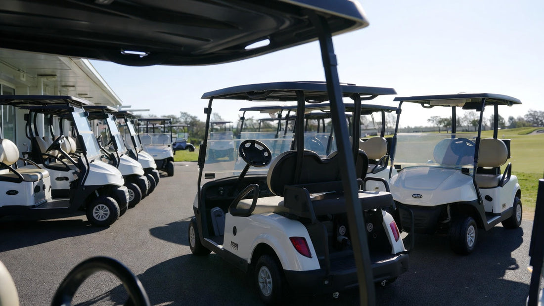 Electric golf carts parked on a golf course during daytime, highlighting professional fleet management and energy-efficient operations.