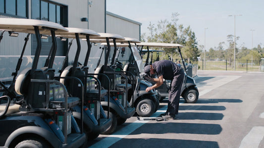 Golf carts being inspected in a maintenance area, highlighting professional fleet preparation and pre-season servicing.