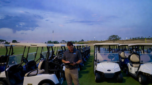 Golf course manager reviewing fleet performance with parked golf carts, highlighting battery warranty concerns and operational challenges.