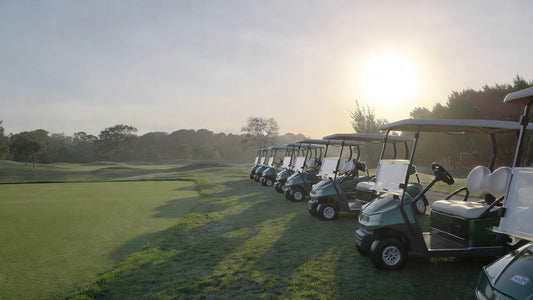 Golf cart fleet parked on a golf course during early morning, representing carts returning to service after a period of inactivity.